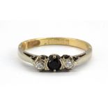 A 9ct yellow gold ring set with sapphire flanked by brilliant cut diamonds, (N.5).