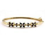 An 18ct yellow gold (stamped 18k) sapphire and diamond set bangle, L. 5.3cm.