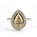An 18ct white gold (stamped 750) cluster ring set with a fancy pear cut yellow diamond surrounded by