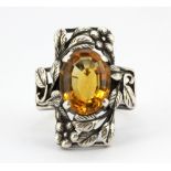 A silver ring set with an oval citrine, (L).