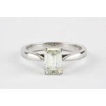 An 18ct white gold (stamped 750) emerald cut diamond set solitaire ring, approx. over 1ct, (K.).