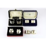 Three pairs of cased hallmarked silver napkin rings and two further silver napkin rings.