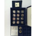 A case containing fourteen commemorative coins, thirteen silver and one other.