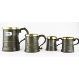 A set of four pewter and brass rimmed graduated tankards, tallest H. 15.5cm.