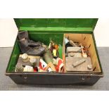 An old military cabin trunk containing a pair of ice skates, old tools, tins and other mixed