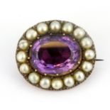 A rose metal (tested 9ct gold) amethyst and seed pearl set brooch, L. 2.2cm.