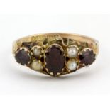 An antique 9ct yellow gold (stamped 9ct) ring set with almandine garnets and seed pearls, (M.5).