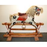 An early 20th century painted wooden rocking horse, L. 113cm H. 94cm.