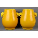 A superb pair of Chinese Imperial yellow Peking glass vases with elephant head handles, H. 27cm.
