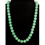 A jadeite jade polished bead necklace, L. 50cm.