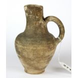 Antiquities interest. An intact pale terracotta jug with handle and pinched spout, minor chip to