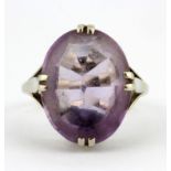 A 9ct white gold (worn stamp 9ct) ring set with an oval cut amethyst, (P.5).