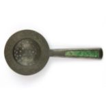 A 1920's Chinese engraved pewter tea strainer, the handle inset with carved jade, L. 18cm.