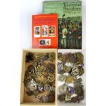 A large quantity of military cap badges and two reference books