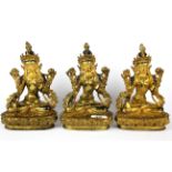 A group of three Tibetan gilt bronze figures of the seated Tara with temple type hand painted faces,