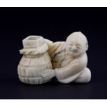 A 19th Century Japanese carved ivory netsuke of a grain seller, H. 3cm.