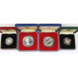 Four boxed silver commemorative coins.