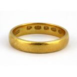 A 22ct yellow gold wedding band, (K).