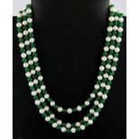 A three row jade and cultured pearl necklace on a white metal clasp.