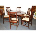 A mahogany dropleaf oval table together with six dining chairs.