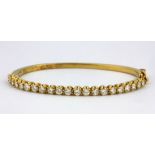 An 18ct yellow gold (stamped 750) bangle set with brilliant cut diamonds, approx. 3ct overall,