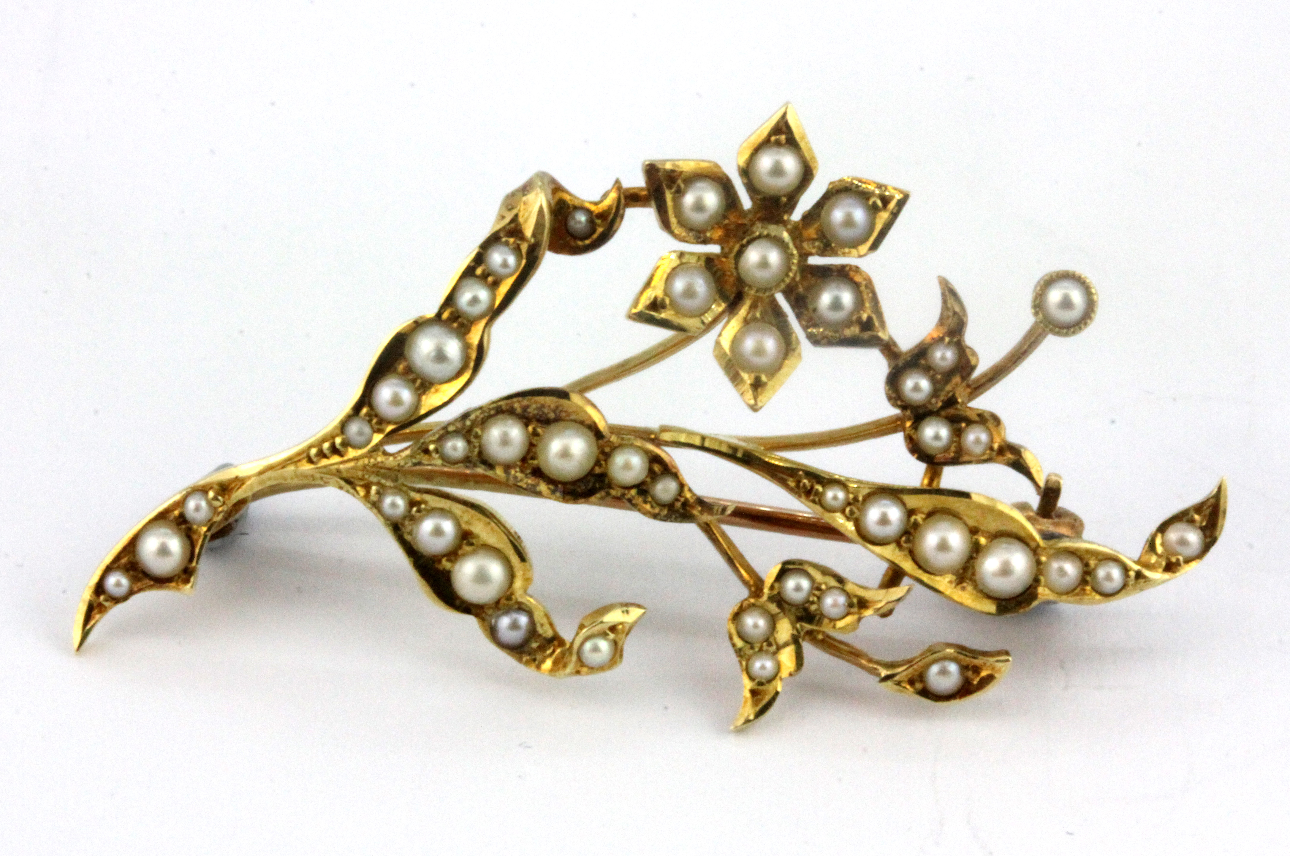 A 15ct yellow gold (stamped 15ct) spray brooch set with seed pearls, L. 4.5cm.