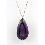 A yellow metal (tested 9ct gold) pendant and chain set with a large pear cut amethyst, L. 3.5cm.