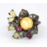 A 925 silver flower shaped ring set with a cream pearl, cabochon cut opals and rubies, (P.5).