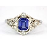 An Art Deco style platinum (stamped plat) ring set with an emerald cut sapphire and brilliant cut