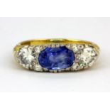 A yellow metal (tested 18ct gold) ring set with oval cut sapphire and brilliant cut diamonds,