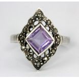 A 925 silver and marcasite ring set with a step cut amethyst, (Q.5).