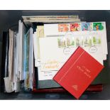 A box of mixed first day cover albums and stamps.