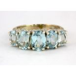A 925 silver ring set with five oval cut graduated blue topaz, (M.5).