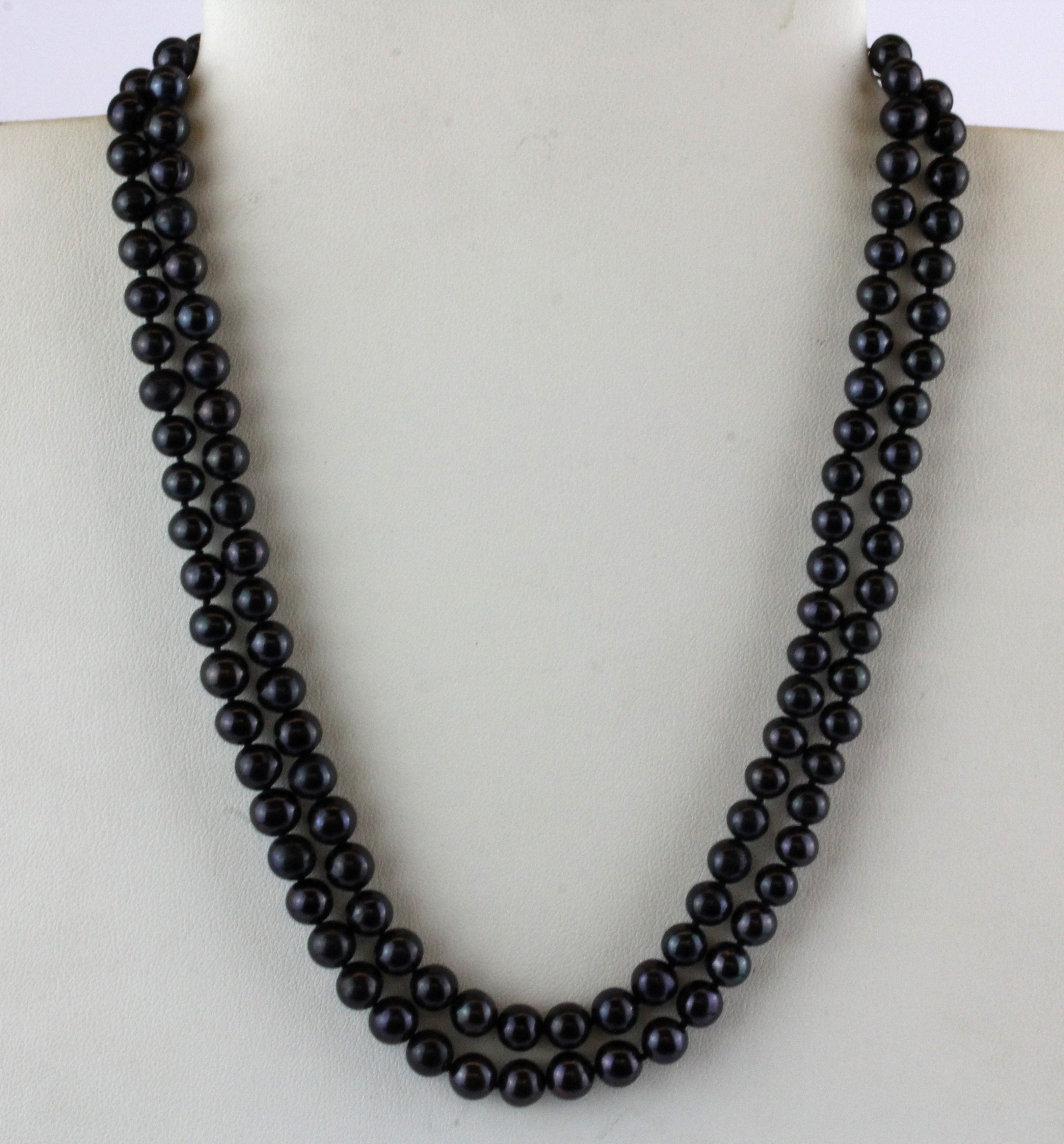 A vintage necklace of black cultured pearls with a white porcelain decorated clasp, pear size 6mm.