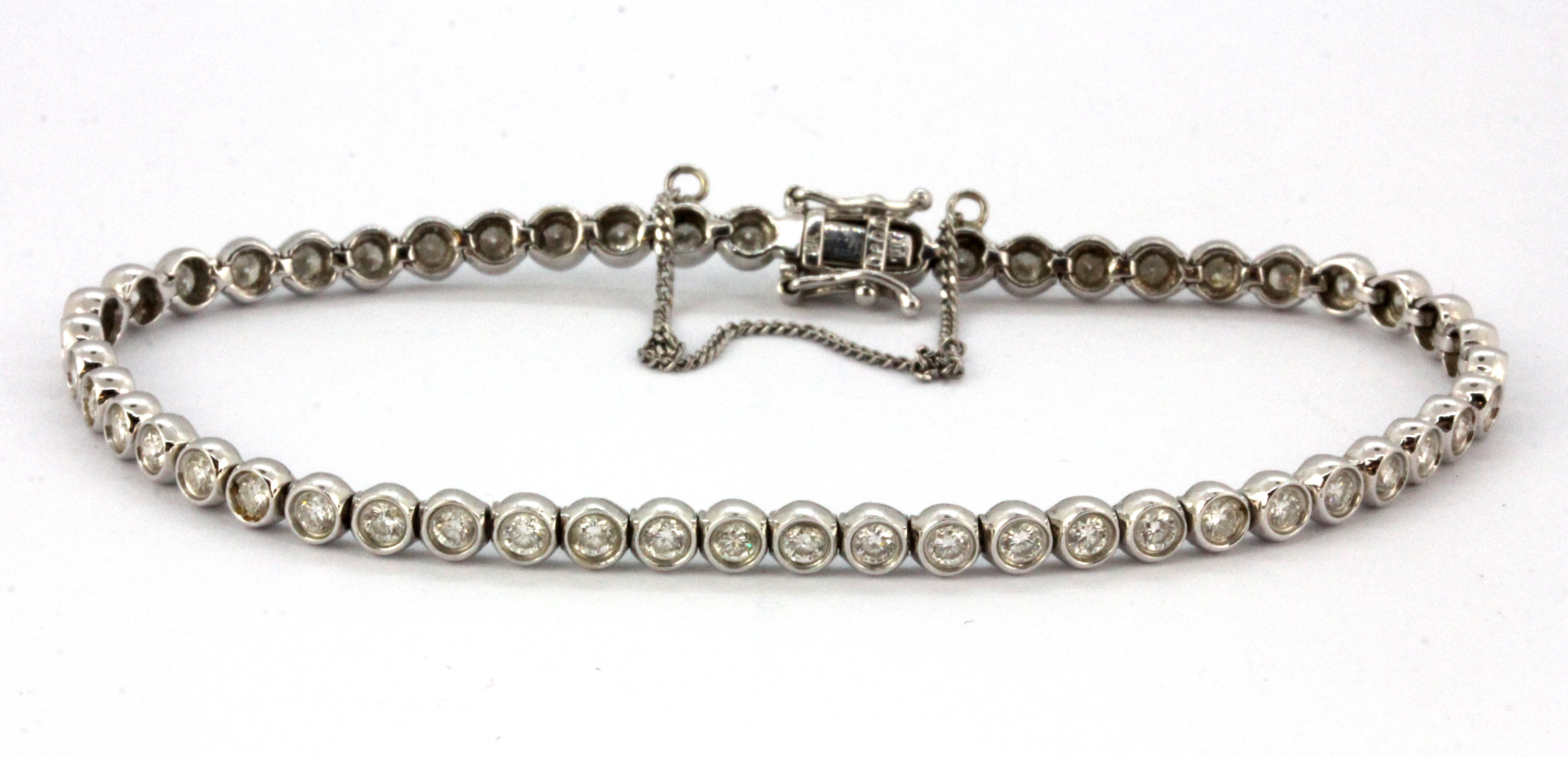 An 18ct white gold (stamped 18k) diamond set tennis bracelet, L. 16cm.