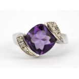 A 9ct white gold ring set with a cabochon cut amethyst and brilliant cut diamond set shoulders, (