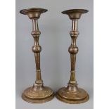 A pair of 19th Century hammered Eastern brass candlesticks, H. 48cm.