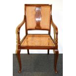 A cane seated walnut armchair.