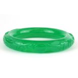 A carved green jade bangle, internal Dia. 6cm W. 1cm.