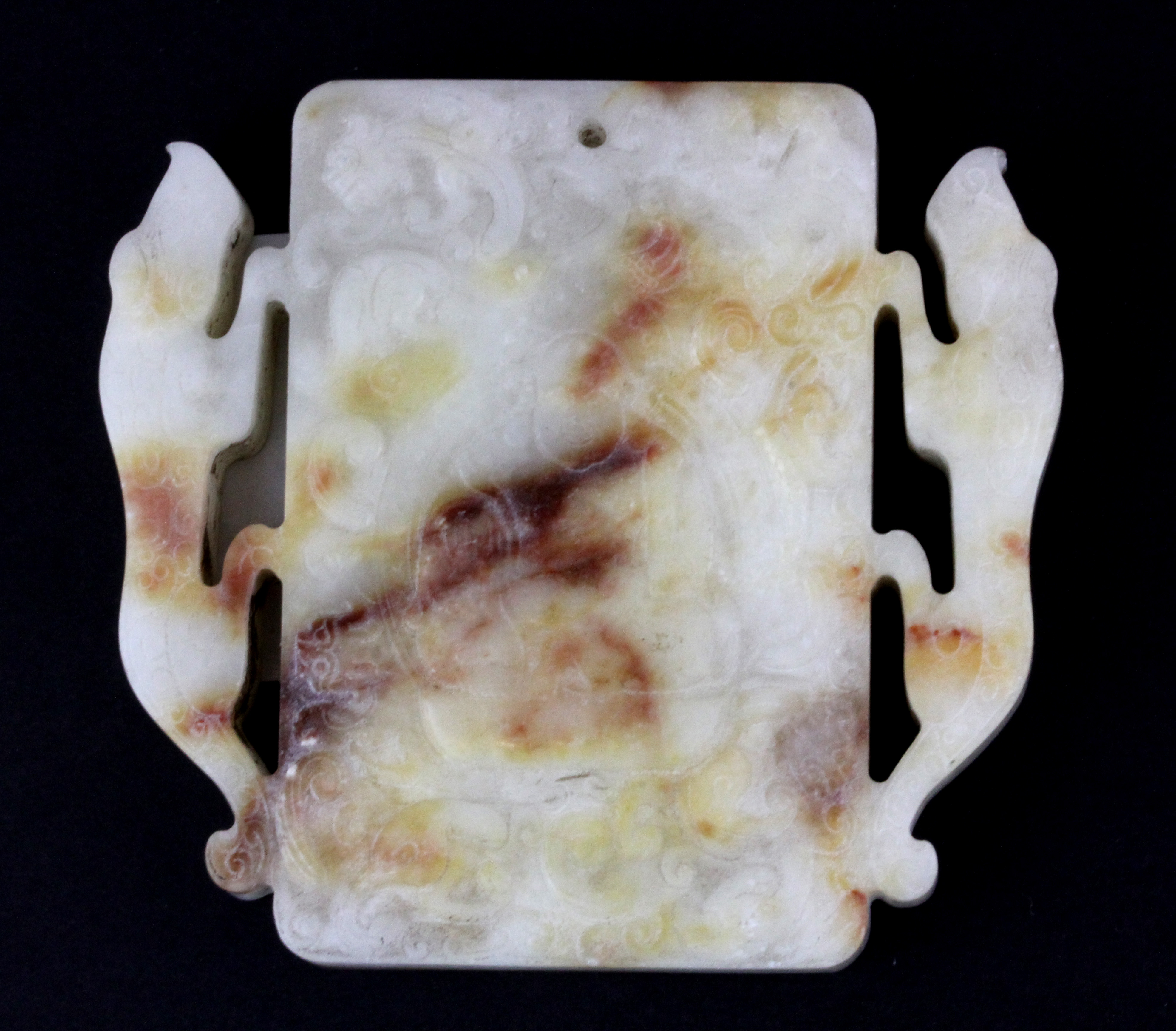 A fine Chinese carved white and russet jade/ hardstone amulet of the seated Putai flanked by two