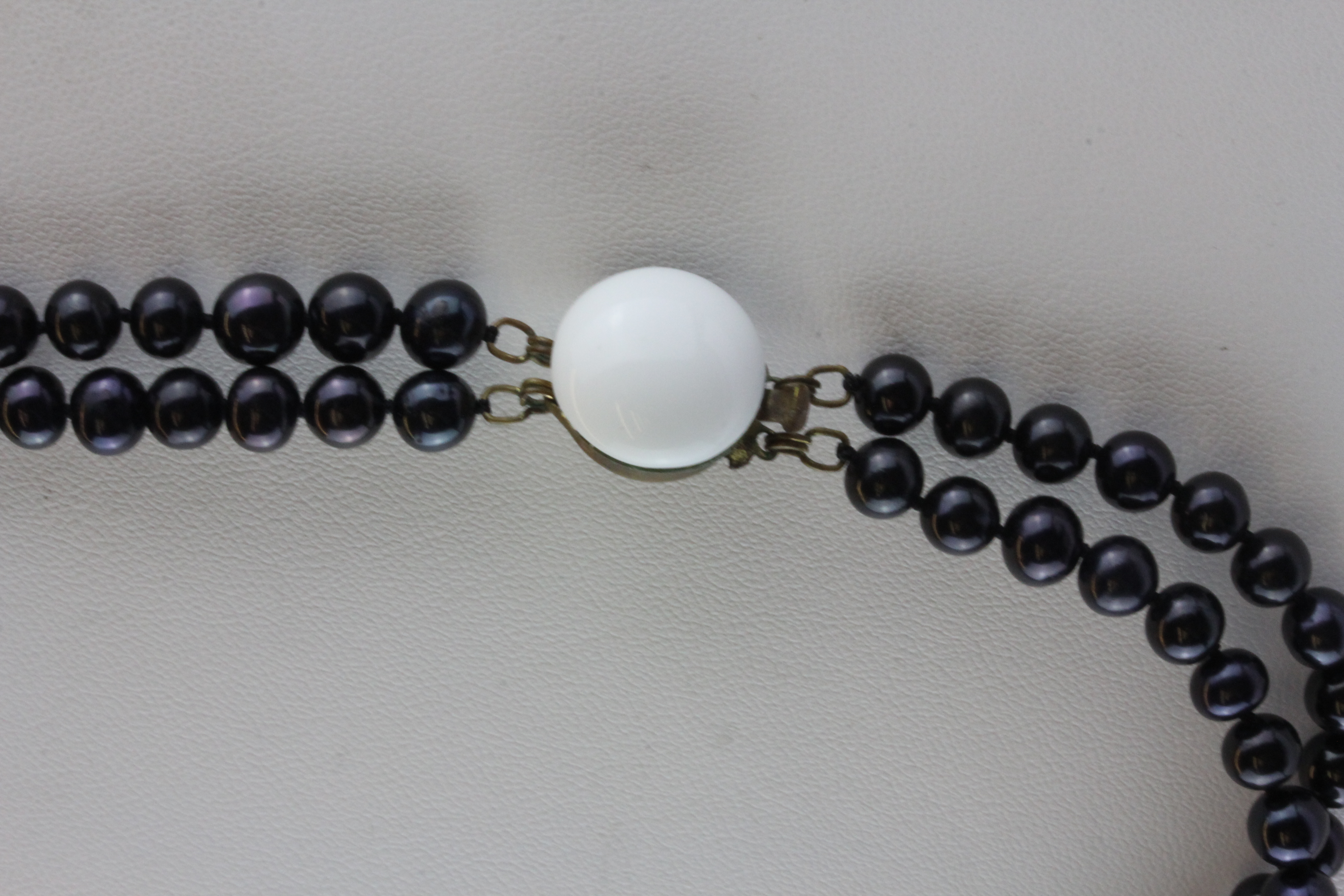 A vintage necklace of black cultured pearls with a white porcelain decorated clasp, pear size 6mm. - Image 2 of 2