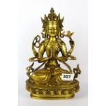 A Tibetan gilt bronze figure of a seated four armed Tara, H. 27cm.