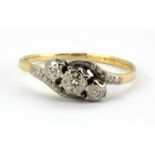 An 18ct yellow and white gold diamond set crossover ring, (P).