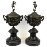 A pair of 19th Century bronze urns and lids on marble bases with Bacchanalian decoration, H. 41cm.