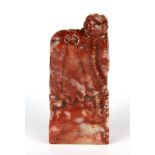 A Chinese carved red and white soapstone seal decorated with lotus, H. 9cm.