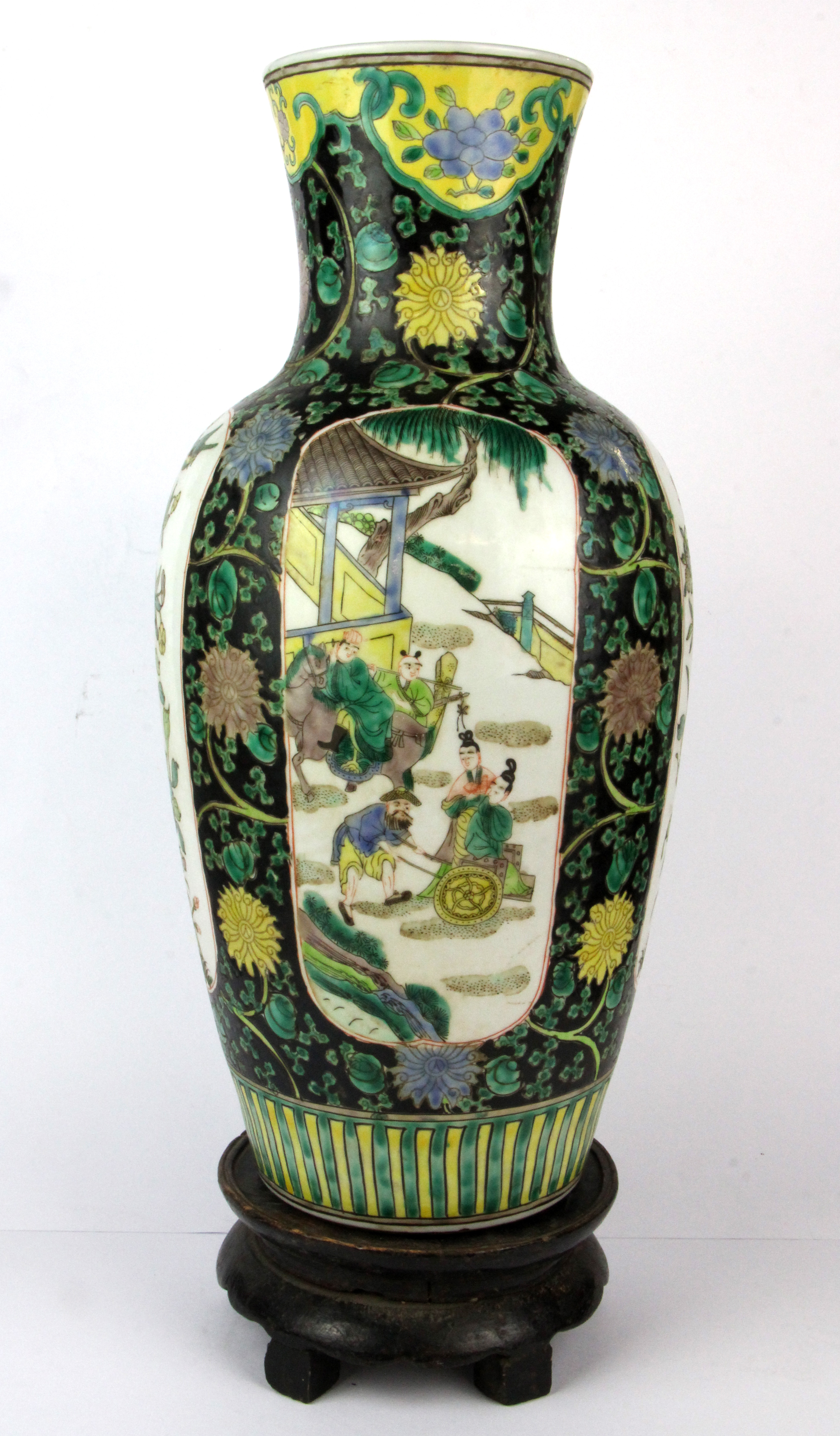 A Chinese 19th/ early 20th Century famille noire decorated porcelain vase and carved wooden stand,