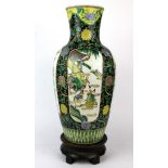 A Chinese 19th/ early 20th Century famille noire decorated porcelain vase and carved wooden stand,