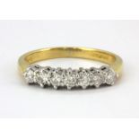 An 18ct yellow and white gold ring set with seven brilliant cut diamonds, (M).