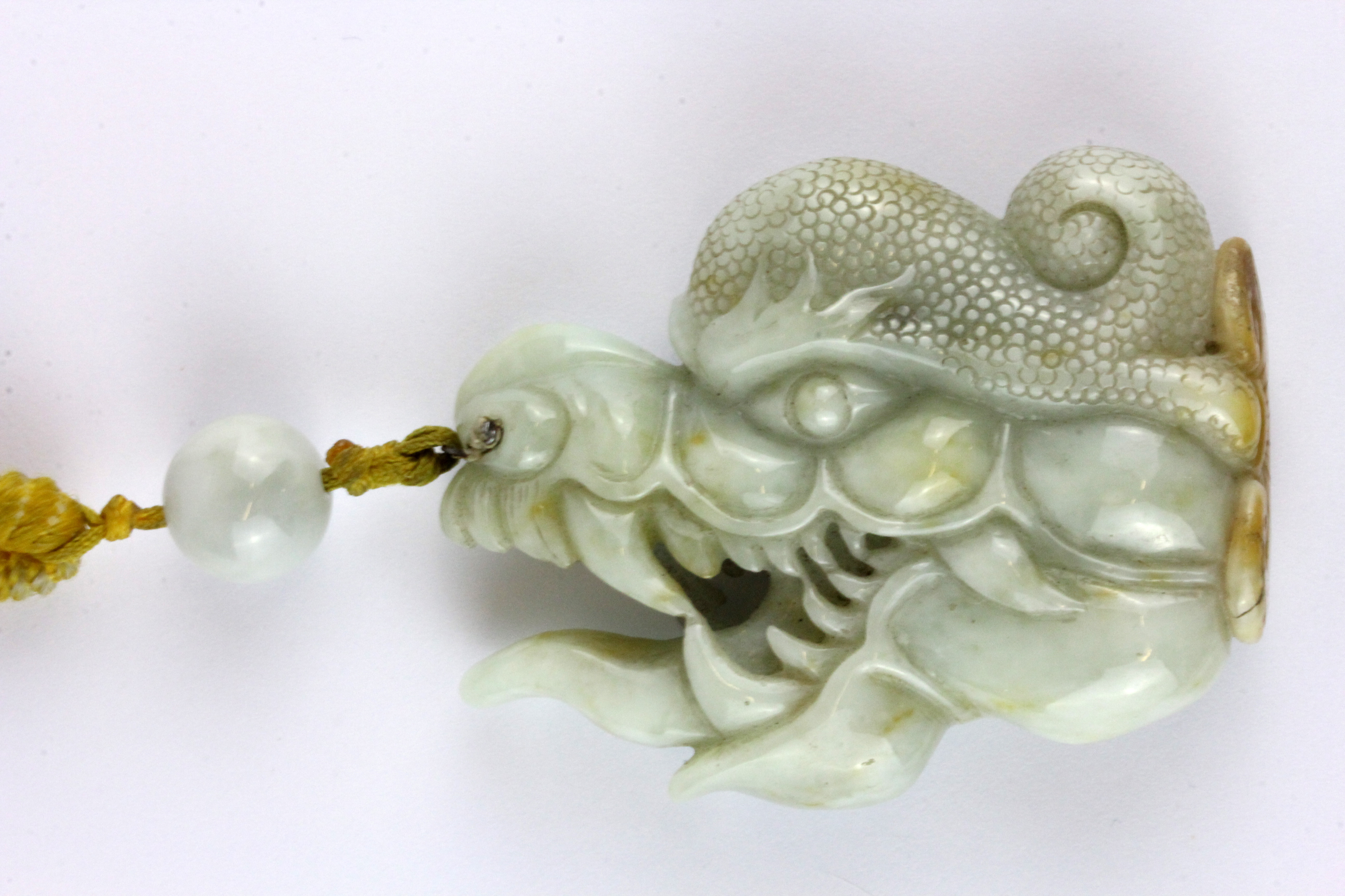 A superb 19th Century Sino-Tibetan carved jade protective amulet with Tibetan yellow silk carrying