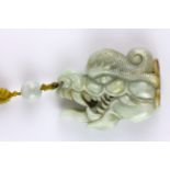A superb 19th Century Sino-Tibetan carved jade protective amulet with Tibetan yellow silk carrying